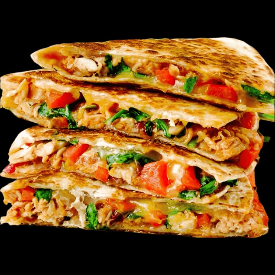 Stack of four quesadilla wedges filled with chicken, melted cheese, red peppers, and spinach.