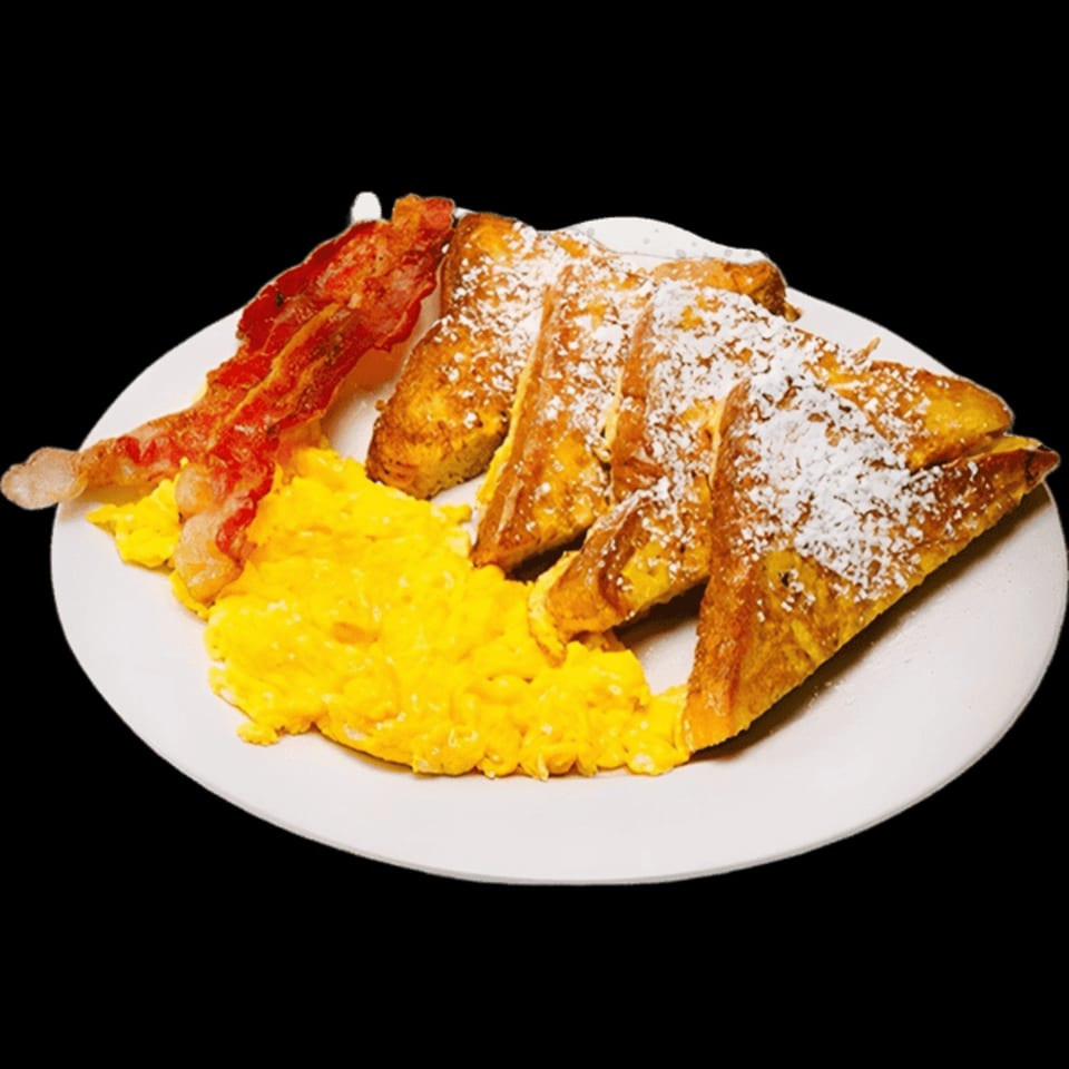 A breakfast plate with four pieces of powdered sugar French toast, scrambled eggs, and two strips of bacon.